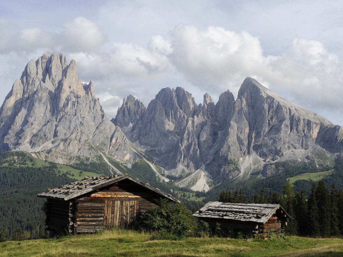 Traditionelle Berghütte mit Blick auf die Berge Berghütte vor Bergpanorama auf der Seiser Alm