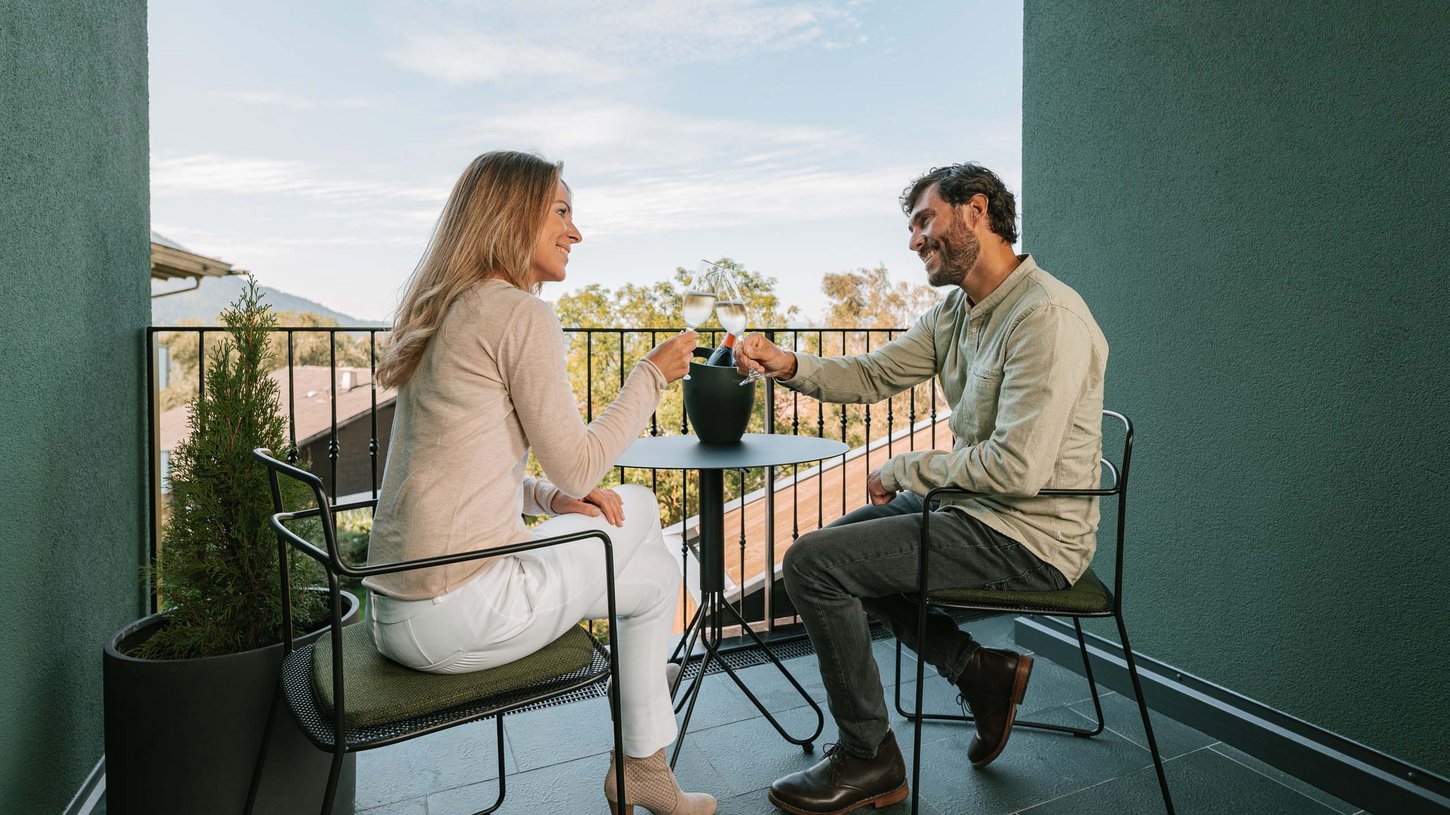 Zwei Personen genießen die Aussicht vom Chalet-Balkon Balkon mit Aussicht