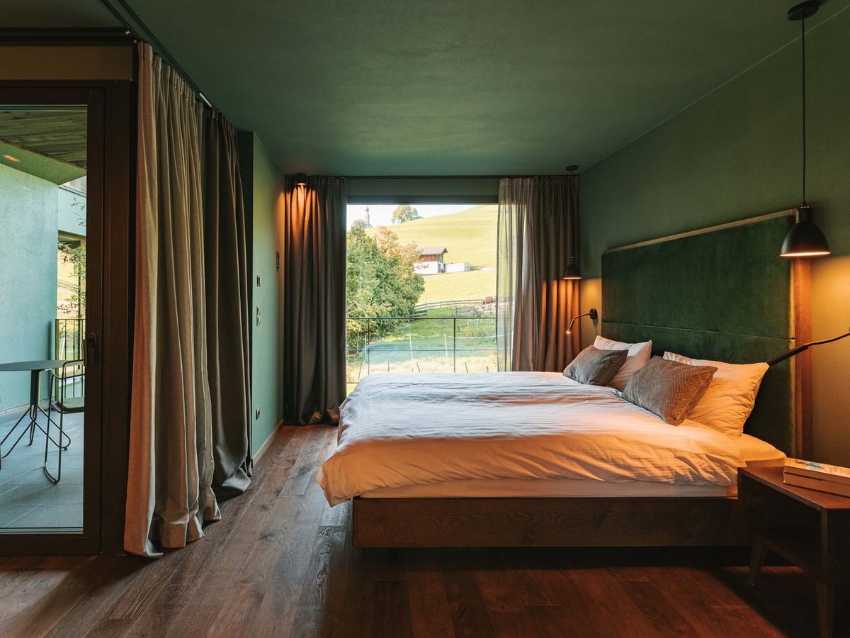 Gemütliches Chalet-Schlafzimmer mit Zugang zum Balkon und schöner Aussicht Chalet-Schlafzimmer mit Balkon und Aussicht