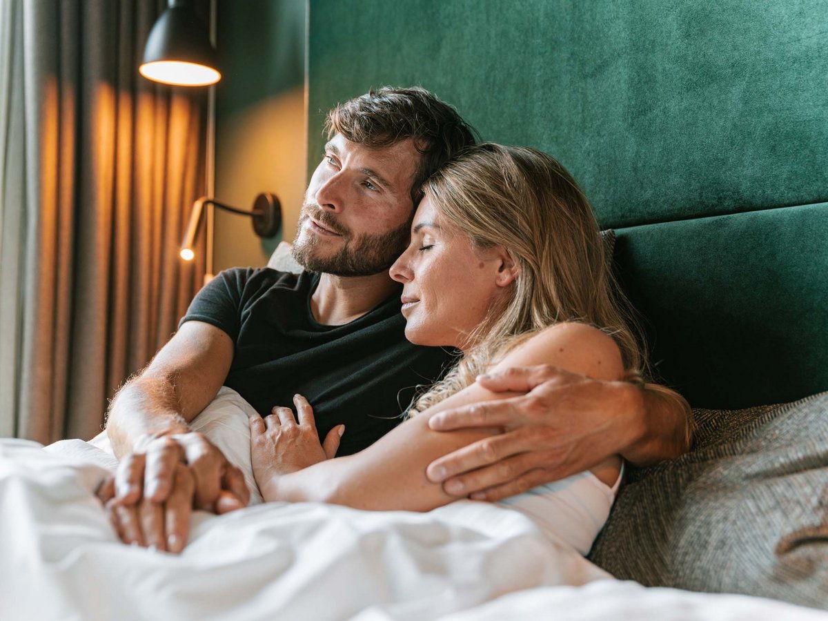 Paar genießt entspannte Momente im gemütlichen Chalet-Bett Paar entspannt im Chalet-Bett